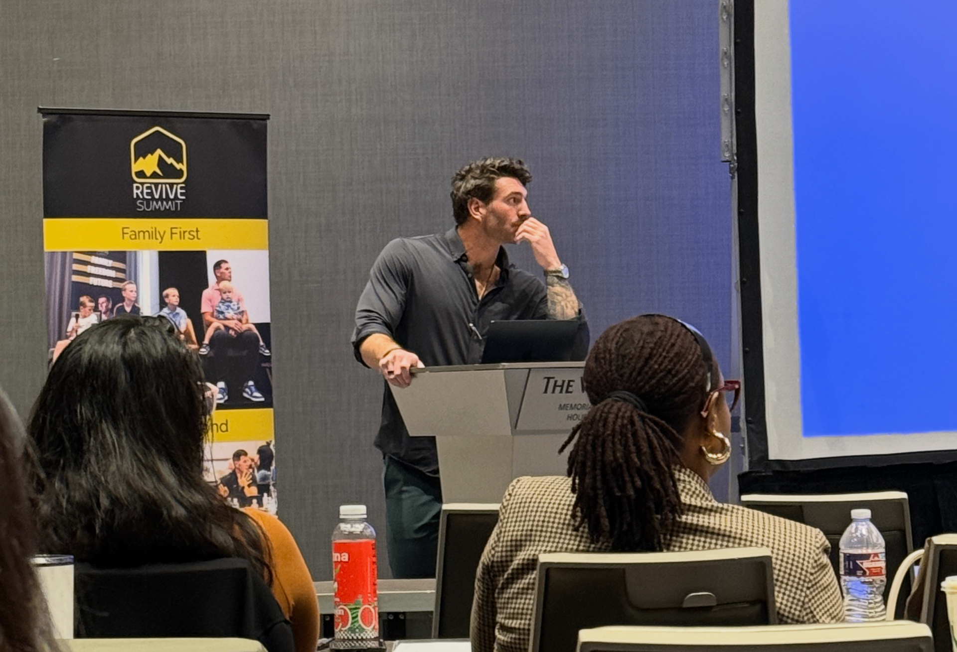Maxwell at the podium presenting FounderOS activation findings